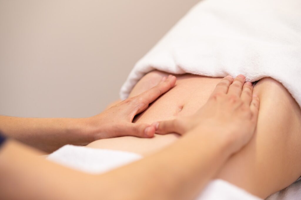 Woman receiving a belly massage at spa salon